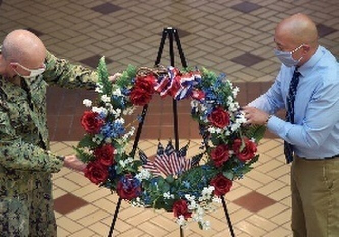 U.S. Navy Captain Dana F. Simon, Commanding Officer of Naval Surface Warfare Center, Philadelphia Division (NSWCPD) and Alex Santos, a NSWCPD Logistics Management Specialist hang a wreath during the command’s Veterans Day Ceremony on Nov 9, 2020 in Philadelphia.. The Veterans Day Ceremony was held to celebrate all Veterans of the U.S. Armed Forces. (U.S. Navy Photo by Kirsten St. Peter, NSWCPD Public Affairs Contractor/Released)