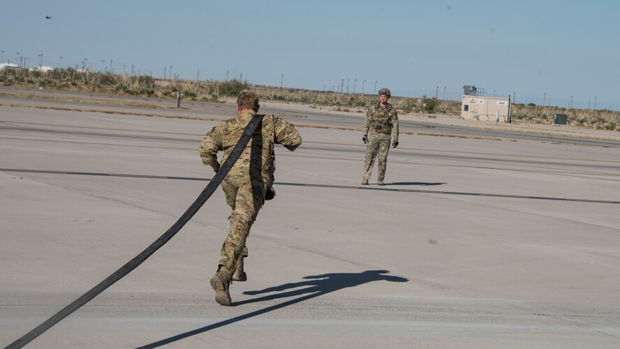 A photo of the wing commander running hose