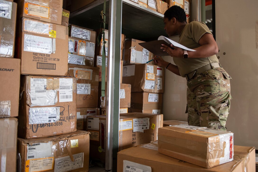 A photo of an Airman counting boxes.