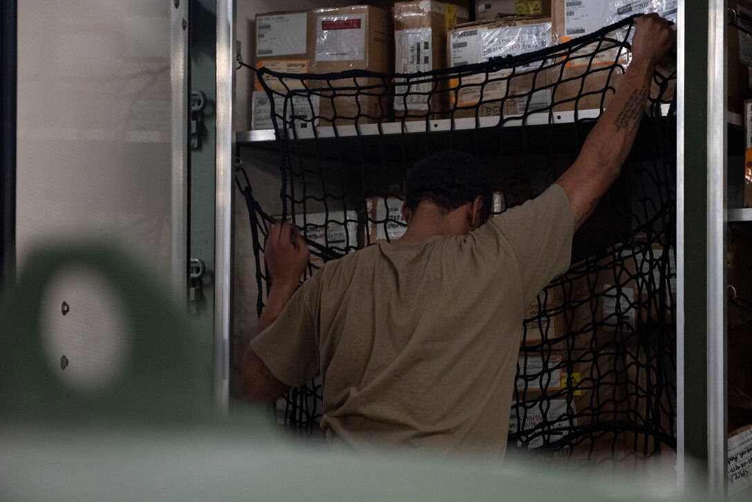 A photo of an Airman securing boxes in a package.