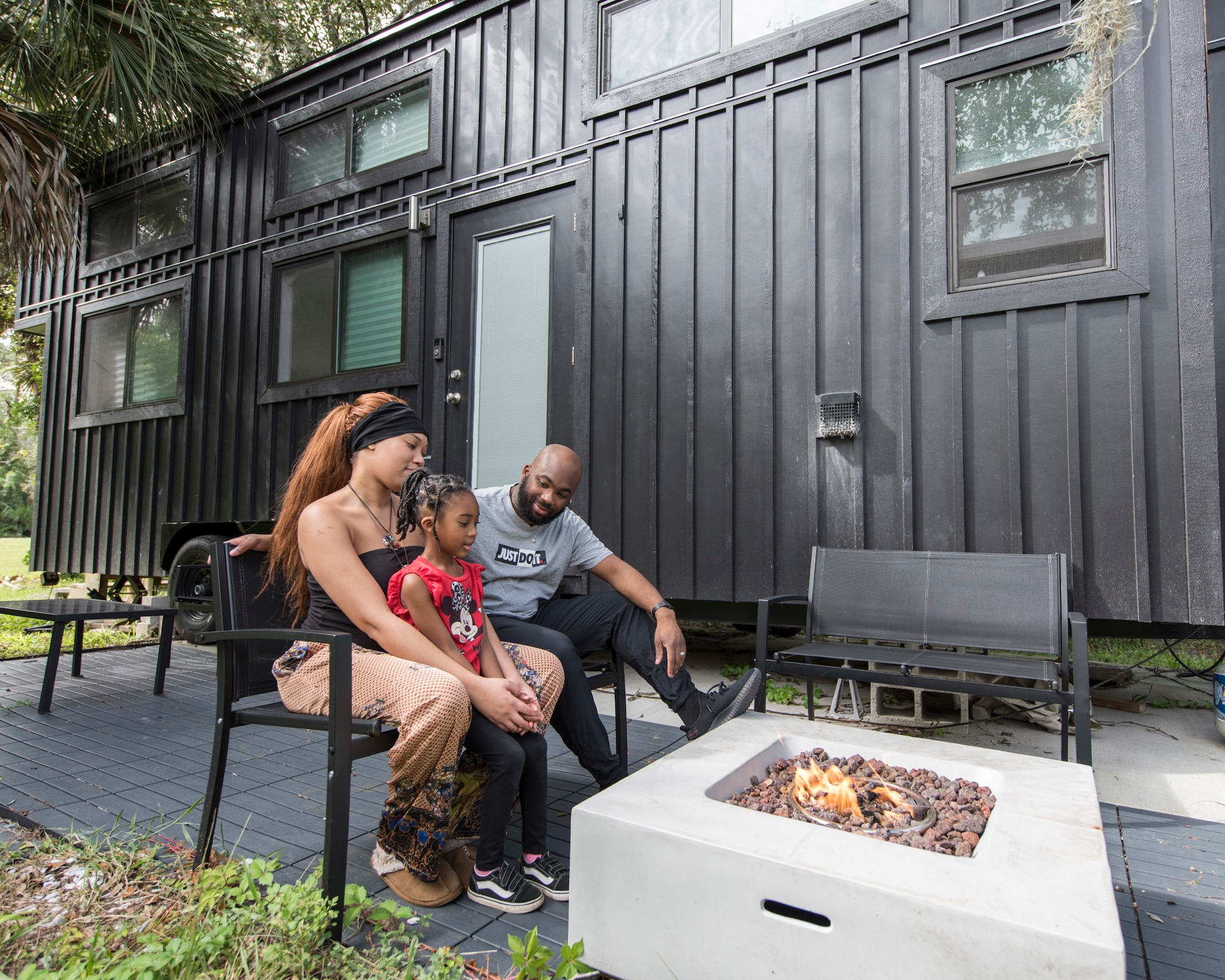 Staff Sgt. Kevin Inniss and his wife, Shanice, sit outside their recently completed Tiny Home with their 5-year-old daughter, Urie, in Cocoa, Fla.  Inniss is a computer knowledge manager with the 709th Cyberspace Squadron at Patrick AFB, Fla. (U.S. Air Force photo by Matthew S. Jurgens)