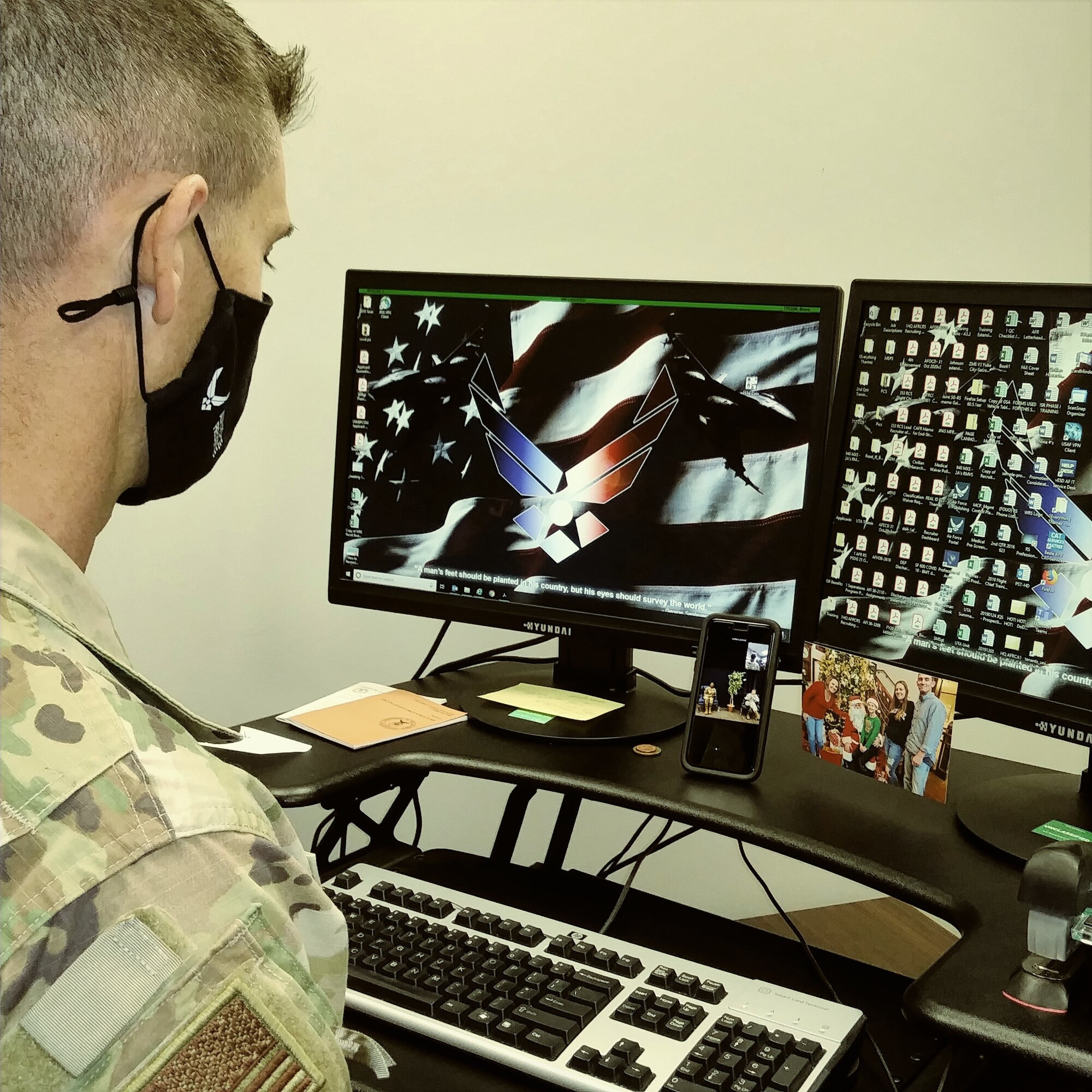 Senior Master Sgt. R. Thames,  Air Force Reserve Command, senior recruiter observes the commander taking questions from an Airman on his smart phone.