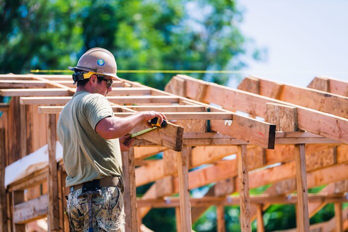 TINIAN, Northern Mariana Islands (Nov. 5, 2020) Builder 3rd Class Matthew Gurrera, from Howell, N.J., deployed with the Seabee expeditionary construction and engineering capability of Task Force 75, marks out trusses for fascia installation in support of Southwest Asia hut construction on Camp Tinian. CTF 75 is 7th Fleet's primary expeditionary task force and is responsible for the planning and execution of maritime security operations, explosive ordnance disposal, diving, engineering and construction, and underwater construction throughout the Indo-Pacific region.