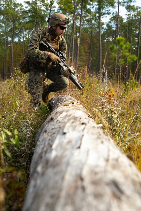 U.S. Marine Corps Lance Cpl. Westley Trotter, a fire team leader with Echo Company, 2nd Battalion, 8th Marine Regiment, 2d Marine Division, clears an obstacle during exercise “Dogs of War” on Fort Stewart, Georgia, Nov. 5, 2020. The exercise was held to improve unit readiness for upcoming training and gain experience operating in a joint environment. Marines conducted multiple air assaults and live fire ranges to improve lethality and cohesion.  (U.S. Marine Corps photo by Cpl. Elijah J. Abernathy)