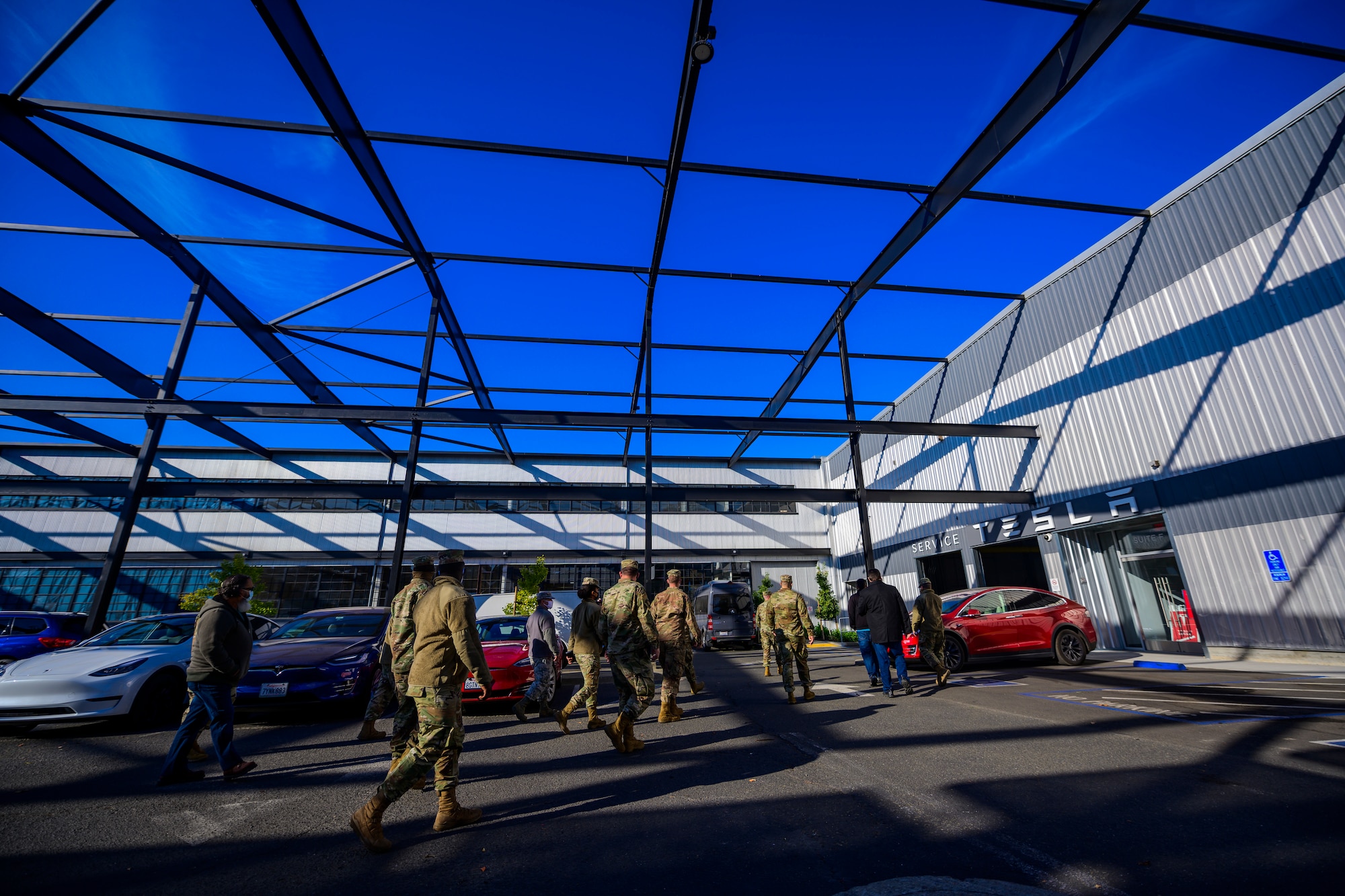 Airmen walk in to a building with Tesla written on it.