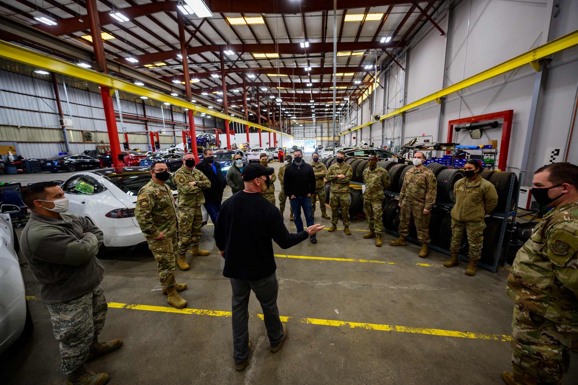 Airmen stand around a man in the center give a briefing.