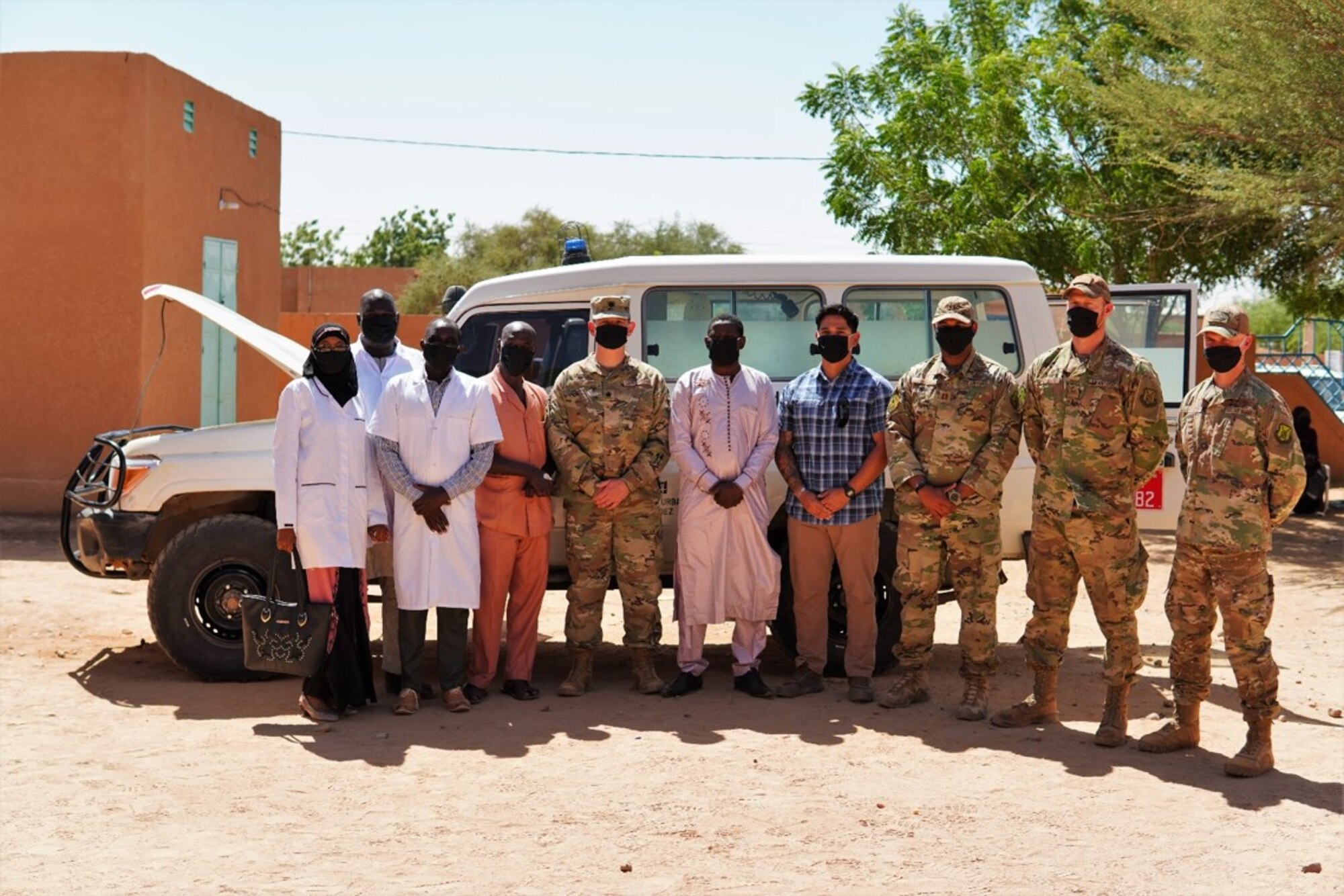 U.S. Air Force Lt. Col. Jeffrey Gipson, fifth from left, 724th Expeditionary Air Base Squadron commander, poses for a group photo with medical staff, the 724th Logistics Readiness Flight commander and vehicle maintenance technicians at the District Sanitaire Commune d'Agadez clinic in Agadez, Niger, Oct. 30, 2020. Airmen with 724 LRF vehicle maintenance gave an unserviceable ambulance a complete makeover, to include new tires and brakes.