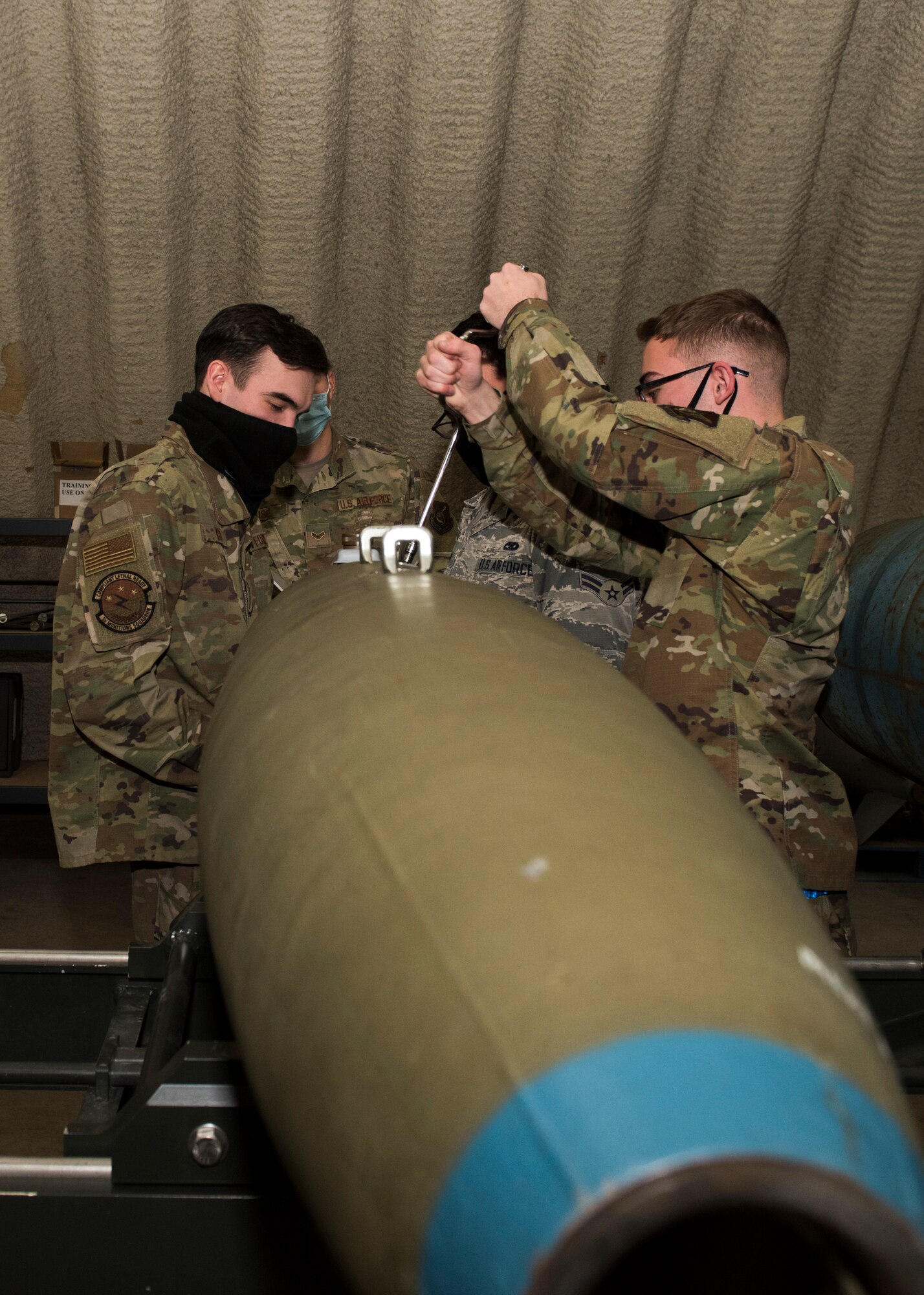 U.S. Airmen assigned to the 3rd Munitions Squadron install a tail-kit assembly onto an inert bomb during a combat munitions training class at Joint Base Elmendorf-Richardson, Alaska, Nov. 5, 2020. U.S. Air Force Tech. Sgt. Nicholas Kern, the 3rd MUNS training section chief, revamped his squadron’s training section and implemented an expanded CMT program that familiarizes ammo troops with a variety of munitions in one location.