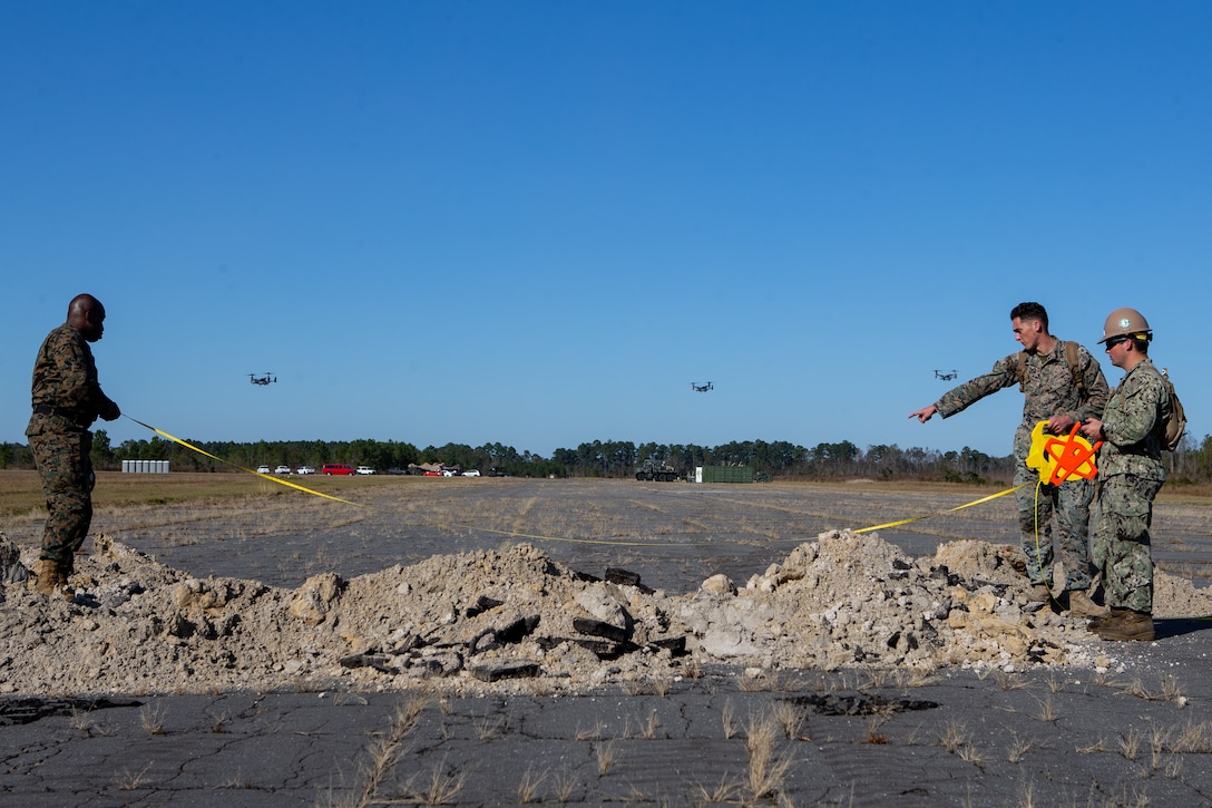 Marines and Sailors measure the diameter of a crater during a base repair after attack training (BRAAT) event at Marine Corps Outlying Field Oak Grove, North Carolina.