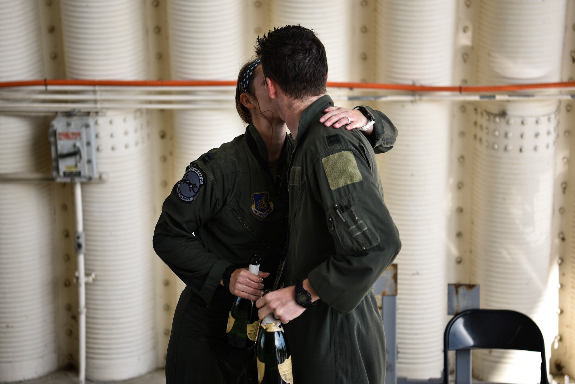 Married pilots embrace each other after a flight.