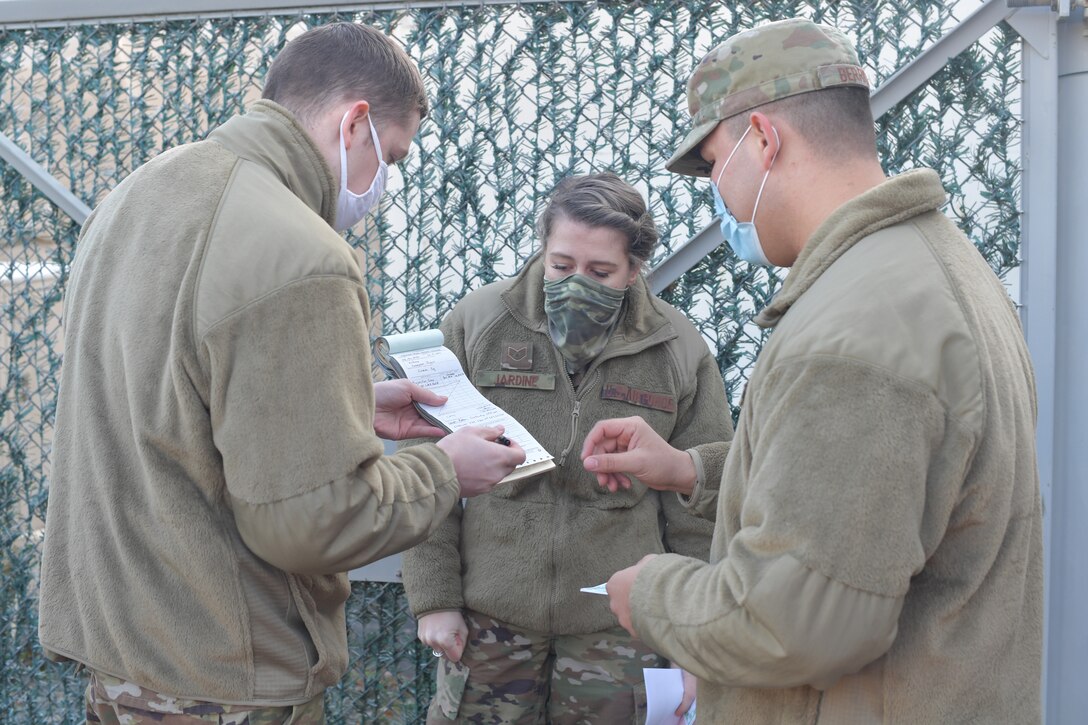 Airmen holding a document to be signed.