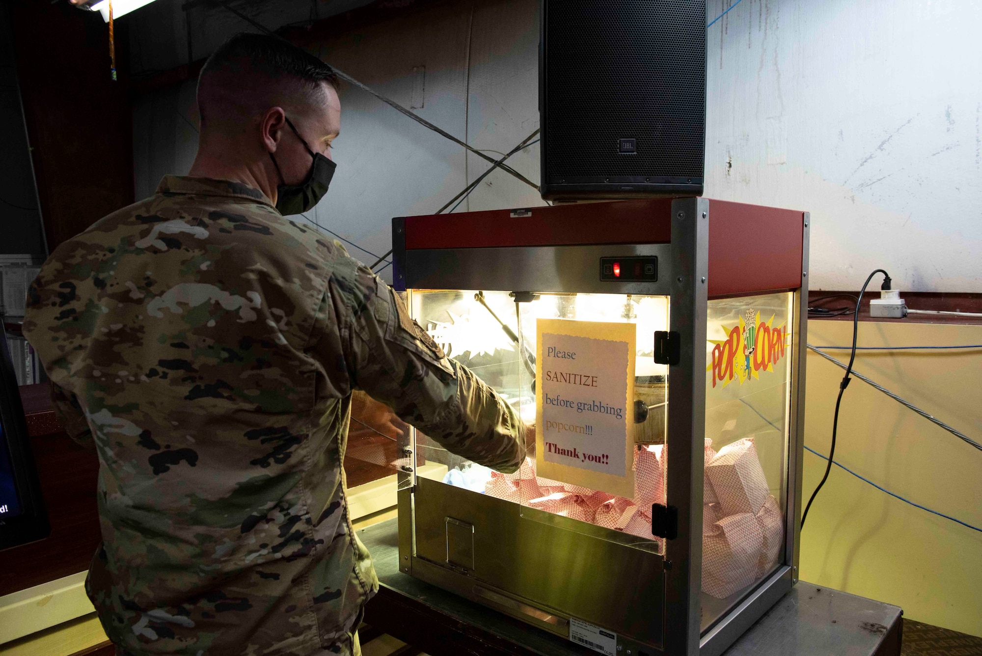 U.S. Air Force Staff Sgt. Thomas Monte, 407th Expeditionary Support Squadron Morale, Welfare and Recreation facility non-commissioned officer in charge, grabs a bag of popcorn at Ahmed Al Jaber Air Base, Kuwait, Nov. 6, 2020.