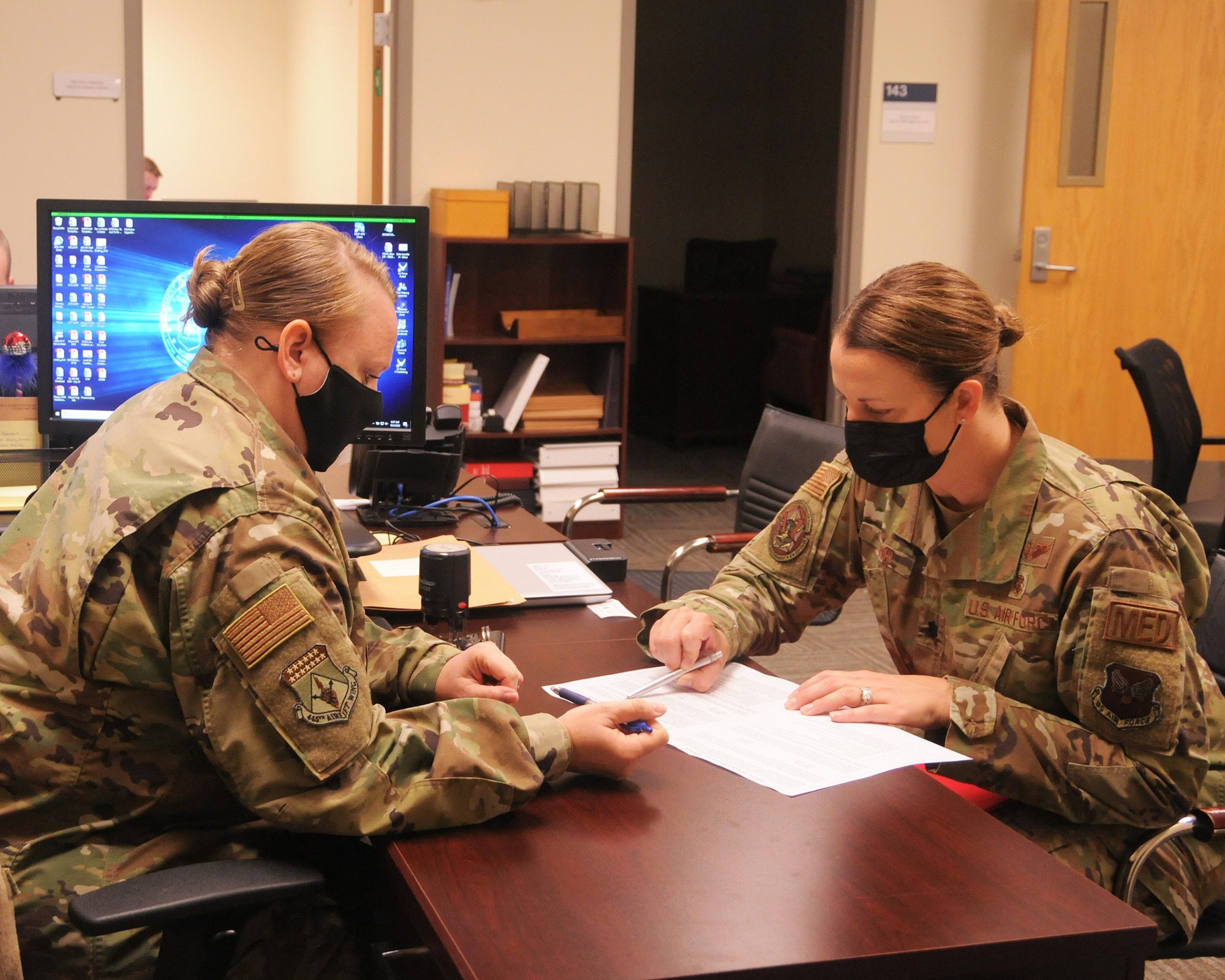 Tech. Sgt. Misty Mayes, 445th Airlift Wing Judge Advocate General office NCO in charge, assists Lt. Col. Jennifer Cowie, 445th Aeromedical Evacuation Squadron operation support flight commander, with an official Power of Attorney for her family care plan.