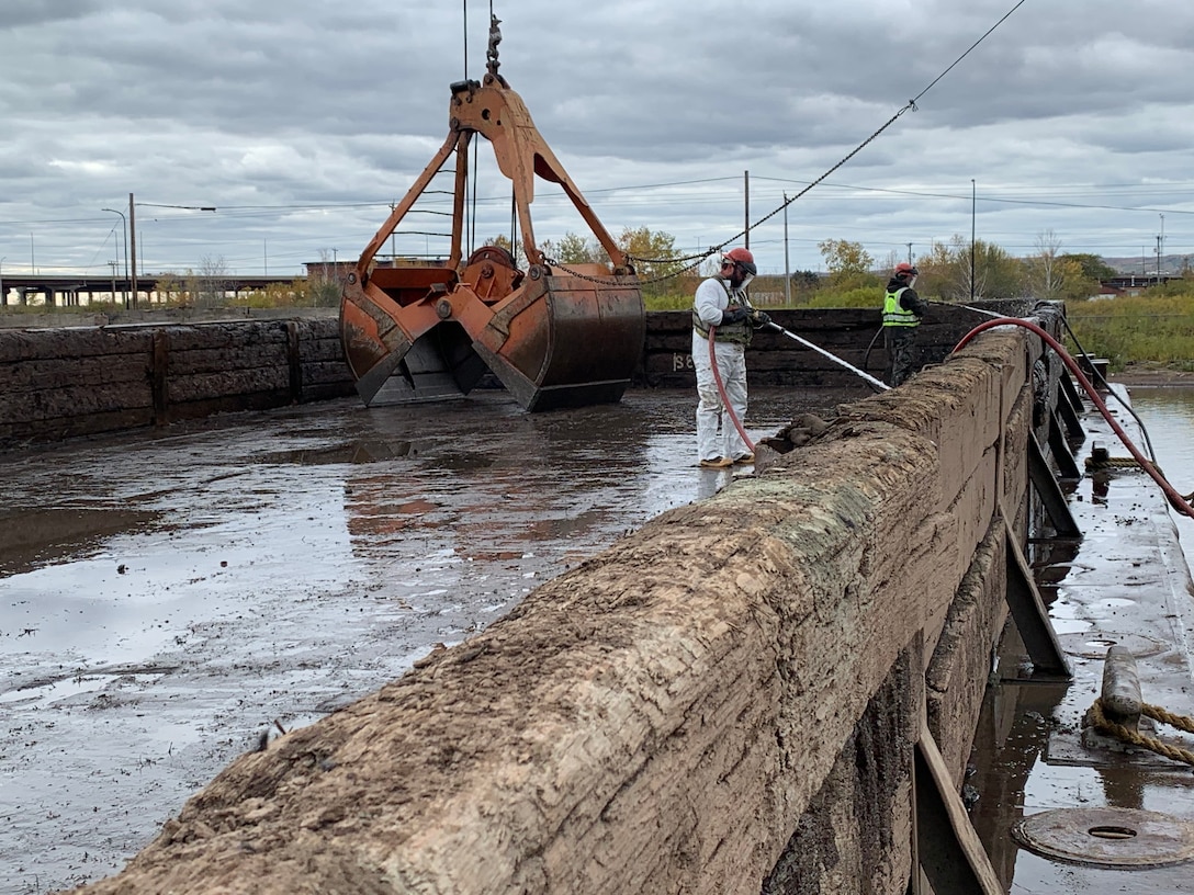 Decontaminating the barge that was used to dewater the contaminated sediments that were dredged out of the AZCON Slip in Duluth, Minnesota before clean material is brought in to construct the cap.