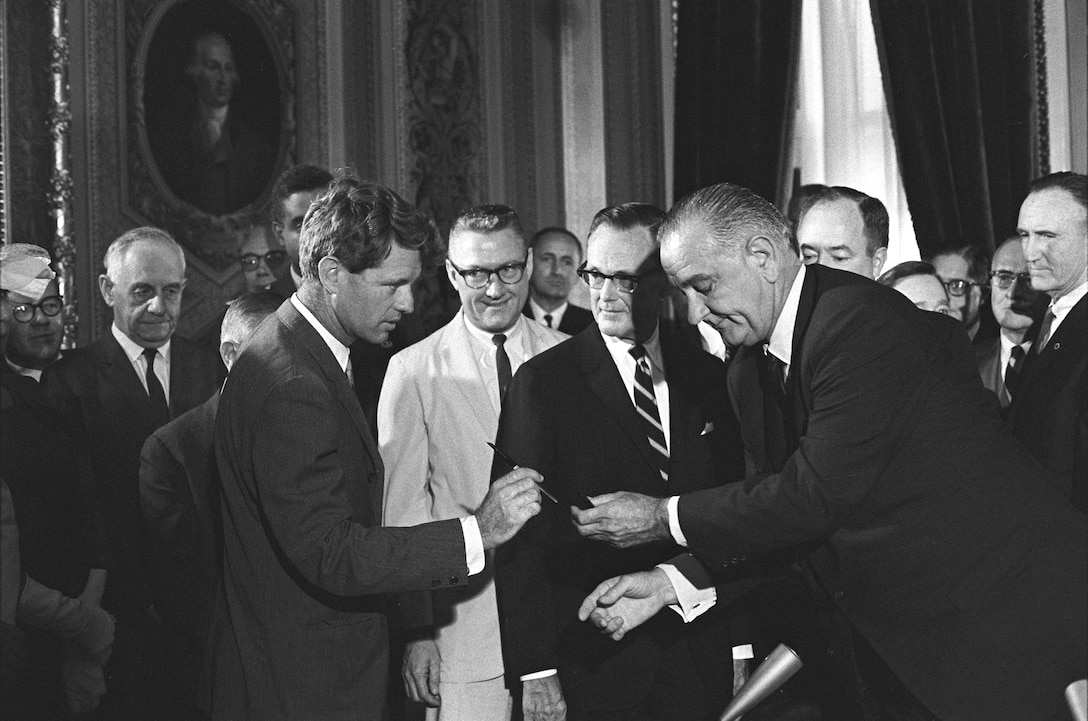 President Lyndon B. Johnson hands pen to Senator Robert F. Kennedy during signing ceremony for Voting Rights Act, U.S. Capitol, Washington, DC, August 6, 1965 (White House Photo Office/LBJ Library/Robert Knudsen)