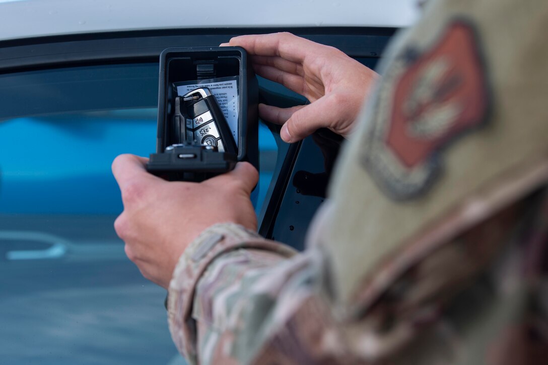 U.S. Air Force Staff Sgt. Eddie Kruse, 100th Logistics Readiness Squadron Ground Transportation Section vehicle operations dispatcher, retrieves car keys from a lockbox on a U-Drive-It vehicle at Royal Air Force Mildenhall, England, Nov. 12, 2020. The ground transportation section envisioned the U-Drive-It vehicle fleet as a safety precaution to reduce the contact between Airmen and customers requiring vehicles for official business. (U.S. Air Force photo by Airman 1st Class Joseph Barron)
