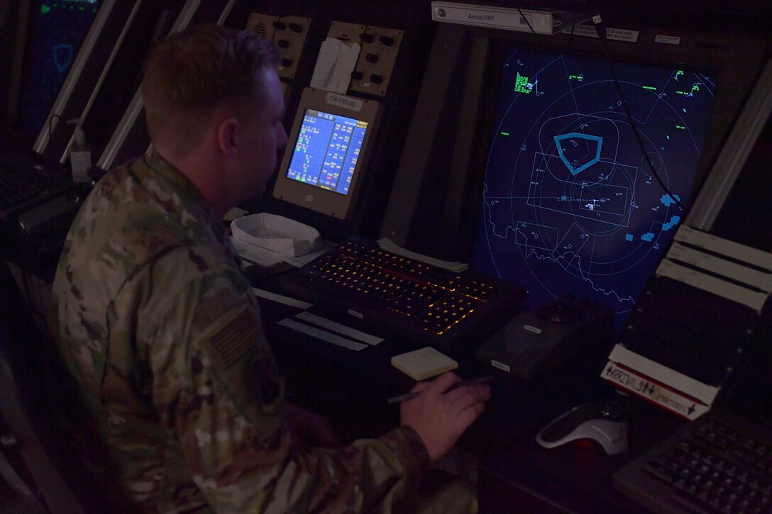 An Airman sitting at a workstation.