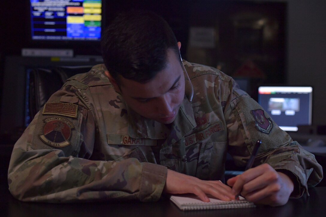 An Airman writing on a notepad.