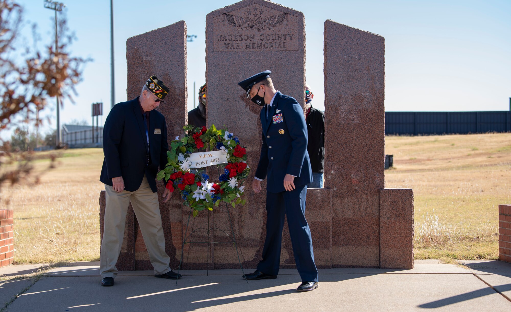 Person places a wreath at memorial..