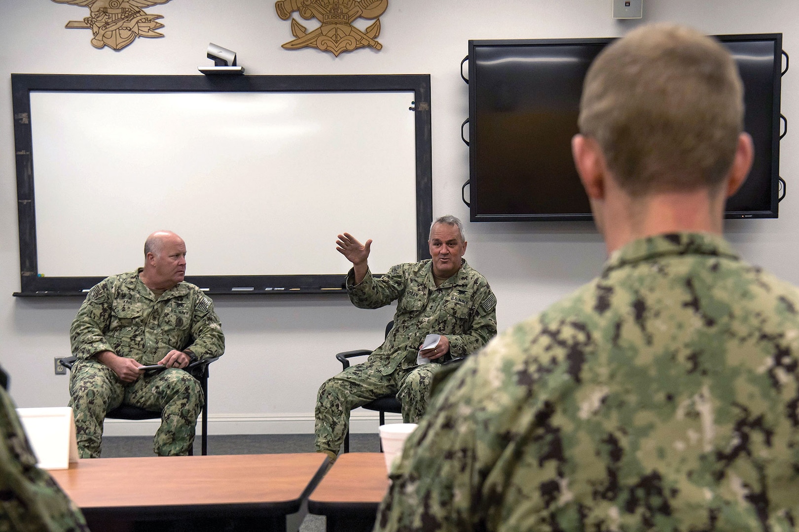 Rear Admiral Collin Green, commander, Naval Special Warfare Command (right), and Force Master Chief William King speak to junior officers and senior enlisted leaders