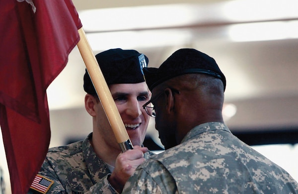 Captain Scott M. Smiley, first blind officer and second Wounded Warrior to hold position of command, passes guidon back to 1st Sergeant Deon E. Dabrio during U.S. Army Warrior Transition Unit at West Point change of command ceremony