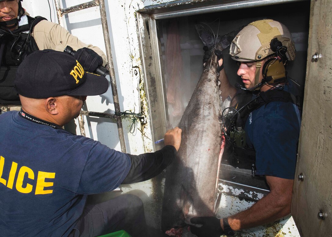 Palauan law enforcement official and Sailor assigned to USS Spruance inspect foreign fishing vessel