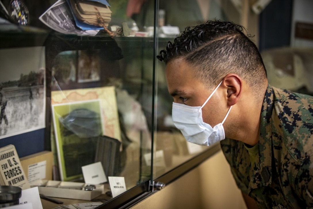 U.S. Navy Petty Officer 3rd Class Roberto Solis, a hospital corpsman with Marine Medium Tiltrotor Squadron 165, Marine Aircraft Group 16, 3rd Marine Aircraft Wing, looks at historical artifacts inside the museum at Field Medical Training Battalion - West on Marine Corps Base Camp Pendleton, California, Sept. 23, 2020. This year, FMTB-West is celebrating its 70th anniversary. In the last 70 years, FMTB-West has trained tens of thousands of corpsmen and medical officers for service with the Fleet Marine Force. (U.S. Marine Corps photo by Lance Cpl. Drake Nickels)