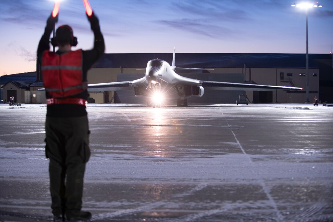 A maintainer assigned to the 28th Aircraft Maintenance Squadron marshals a B-1B Lancer assigned to the 34th Bomb Squadron prior to a Bomber Task Force mission from the continental United States, Nov. 12, 2020. U.S. Air Force maintainers are able to provide mission-ready strategic bombers, under any condition, at any time. (U.S. Air Force photo by Airman Jonah Fronk)