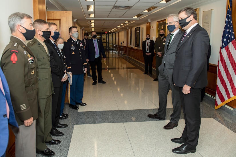 A group of men wearing masks stand in a hallway.
