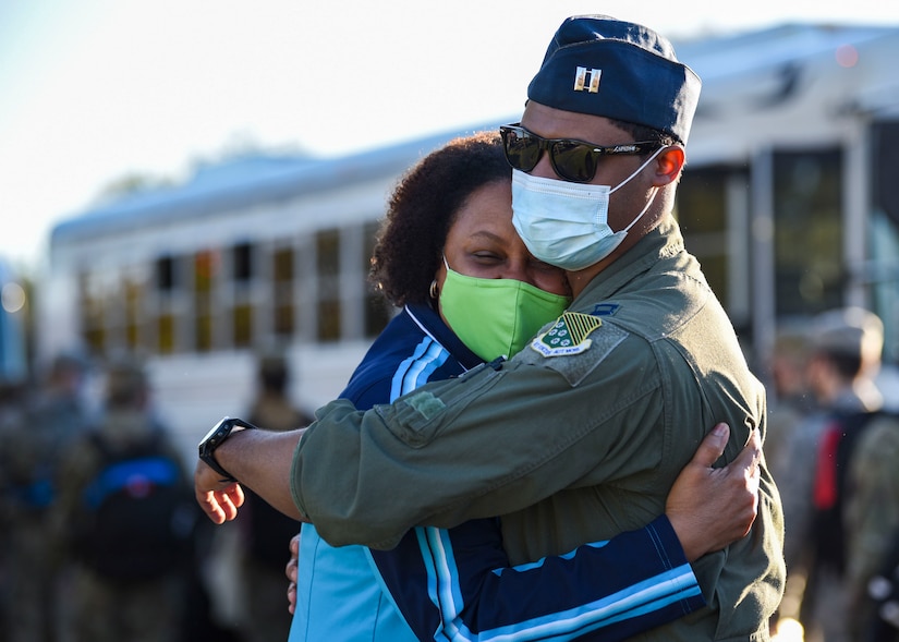 An Airman gives his mother a hug goodbye before boarding a bus to leave for deployment.