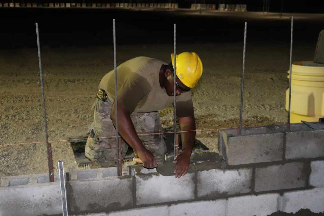 A member of the 310th Engineering Detachment works on construction a Joint Air Ground Station building in Qatar. The building is being built using troop labor from a design from the U.S. Army Corps of Engineers Middle East District's Center of Standardization for Nonpermanent Facilities (COS). The COS maintains a library of off the shelf designs that can be adapted for almost any purpose. Using COS designs can save significant time and money in the construction process.