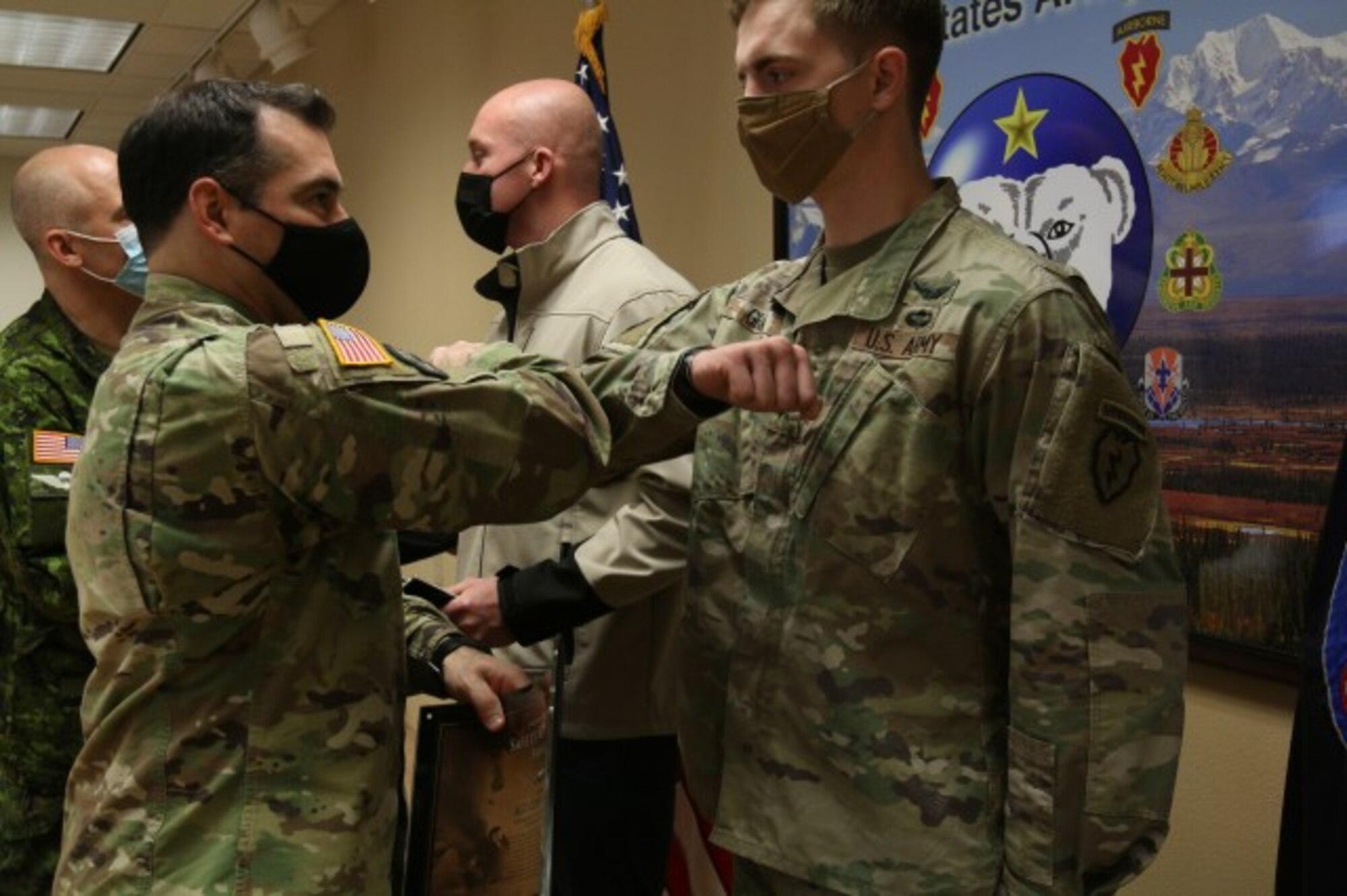 Col. Chris Landers, commander of 4th Infantry Brigade Combat Team (Airborne), 25th Infantry Division, congratulates Sgt. Cody Grant, for receiving the U.S. Army's Safety Guardian Award at Joint Base Elmendorf-Richardson, Alaska, Nov. 12, 2020. Grant and his friend Staff Sgt. Joseph Kellogg were riding dirt bikes when they encountered an unconscious boy after he crashed on his ATV. They provided first aid and were able to contact emergency responders to get the child evacuated. (U.S. Army photograph by Staff Sgt. Alex Skripnichuk)