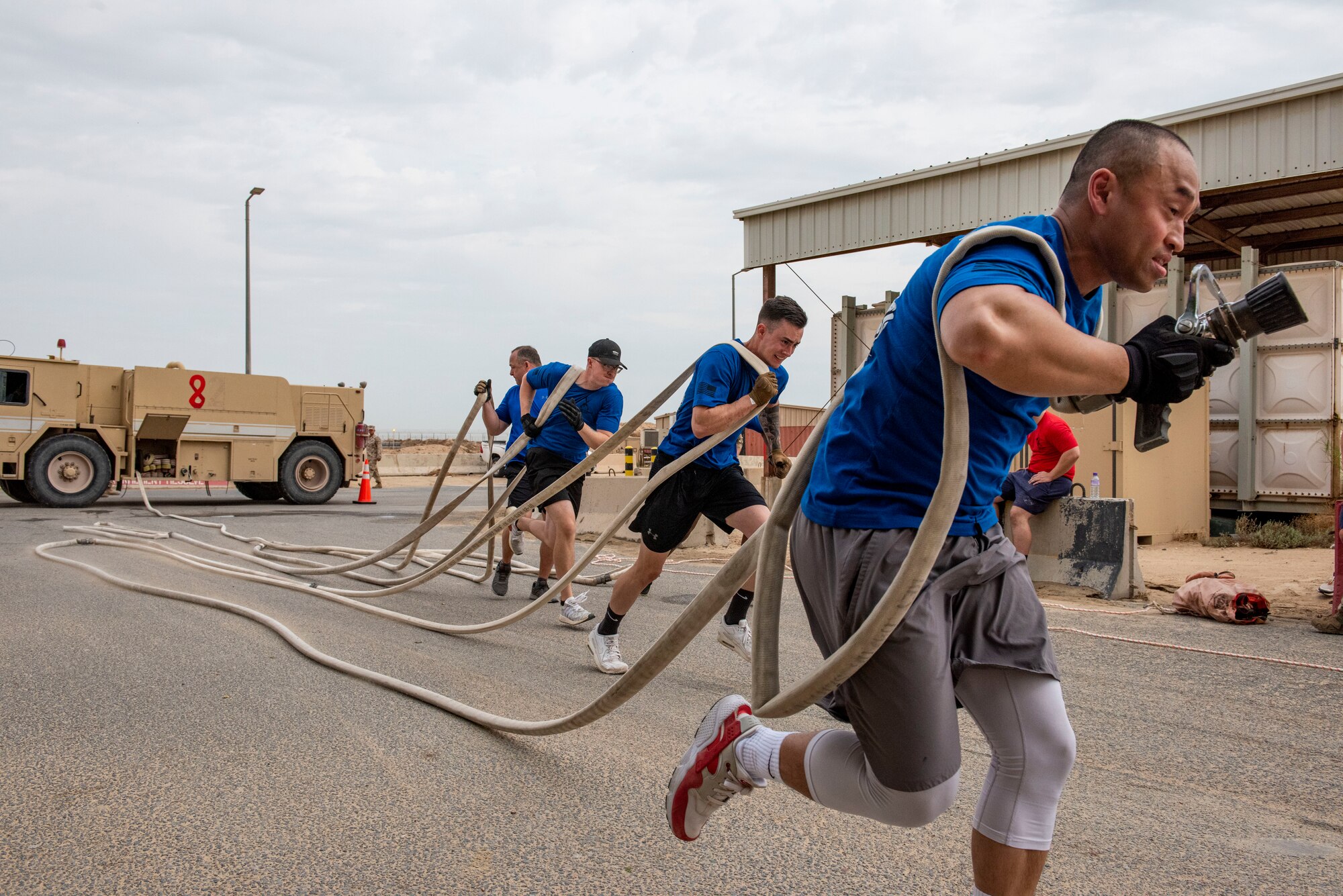 U.S. Air Force Airmen assigned to the 407th Expeditionary Security Forces Squadron run with a hose during the Battle of the Badges event at Ahmed Al Jaber Air Base, Kuwait, Nov. 11, 2020.