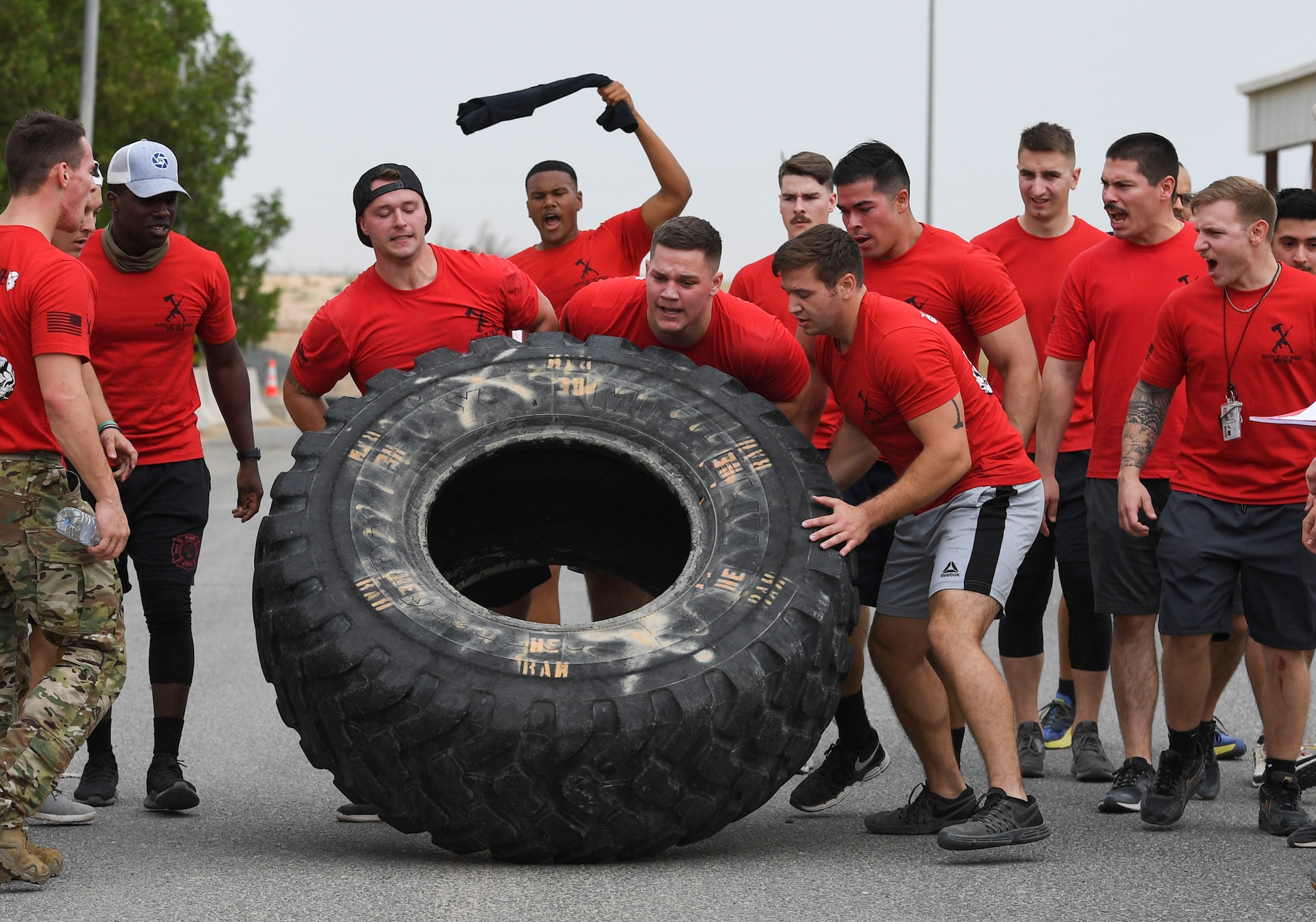 U.S. Air Force Airmen assigned to the 407th Expeditionary Civil Engineer Squadron flip a tire during the Battle of the Badges event at Ahmed Al Jaber Air Base, Kuwait, Nov. 11, 2020.