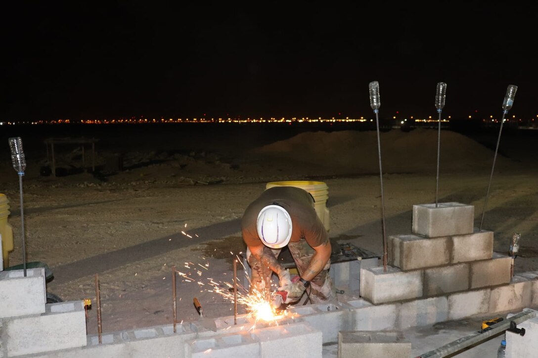A member of the 310th Engineering Detachment works on construction a Joint Air Ground Station building in Qatar. The building is being built using troop labor from a design from the U.S. Army Corps of Engineers Middle East District's Center of Standardization for Nonpermanent Facilities (COS). The COS maintains a library of off the shelf designs that can be adapted for almost any purpose. Using COS designs can save significant time and money in the construction process.