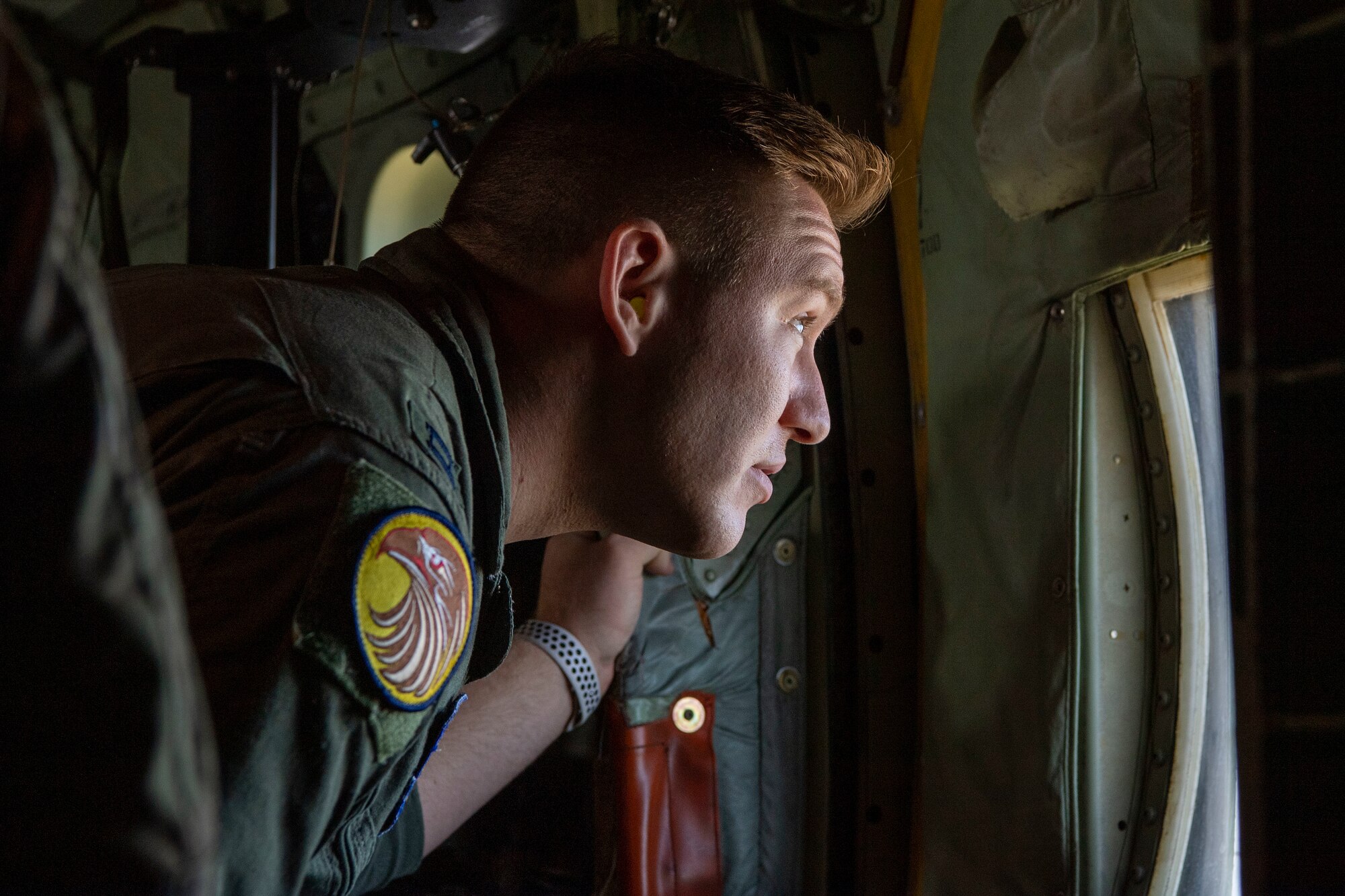 A student pilot looks out the side window of a C-130J.