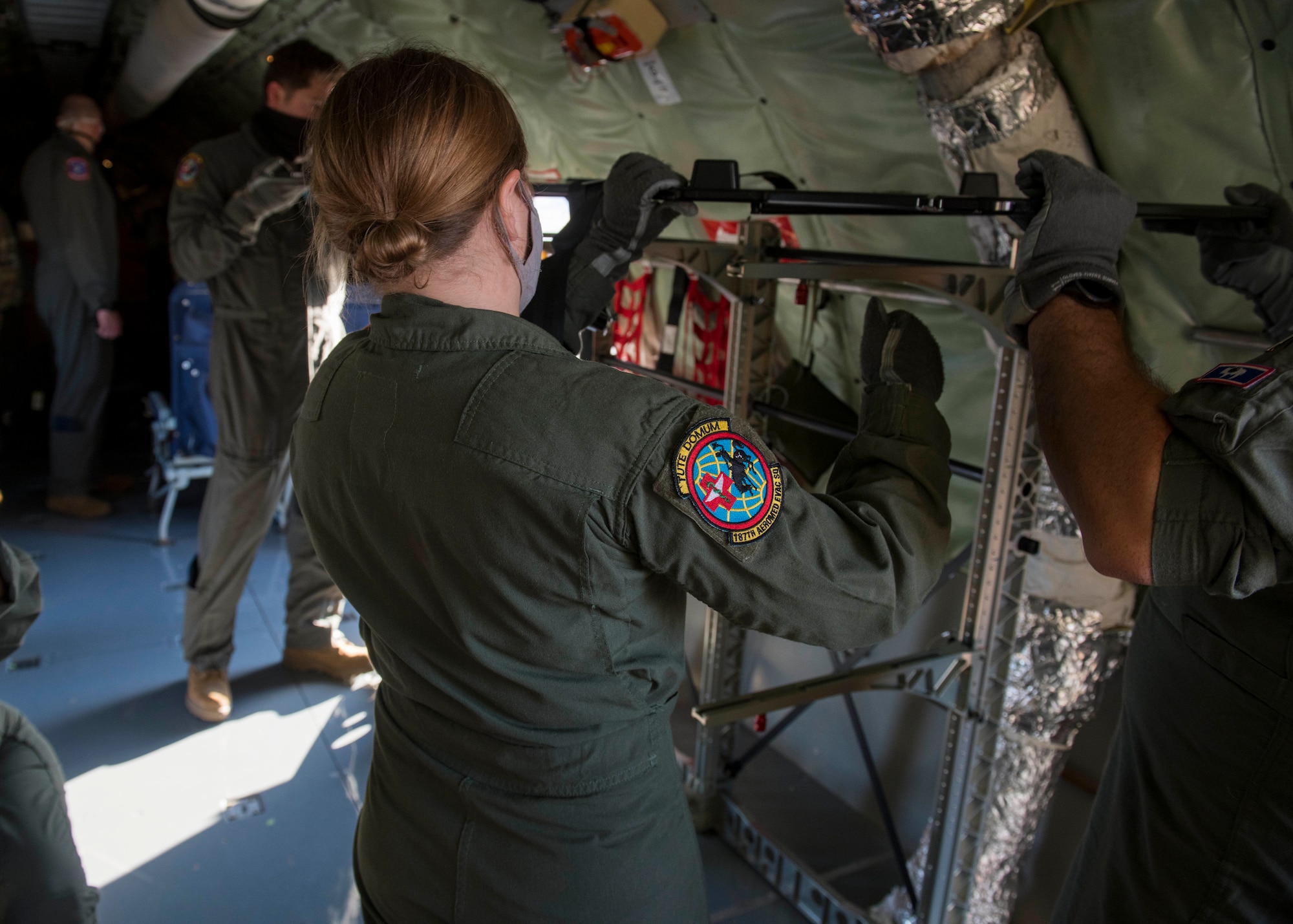Wyoming Air National Guard Senior Airman Natalie Christofferson, 187th Aeromedical Evacuation Squadron medical technician, configures a stanchion on a KC-135 Stratotanker prior to an aeromedical evacuation mission at Travis Air Force Base, California, Nov. 7, 2020. Even though the primary mission of the KC-135 is extending Global Reach through air refueling, Stratotankers are capable of supporting a variety of missions including cargo delivery, AE, passenger delivery, serving as a communication platform and more. (U.S. Air Force photo by Senior Airman Lawrence Sena)