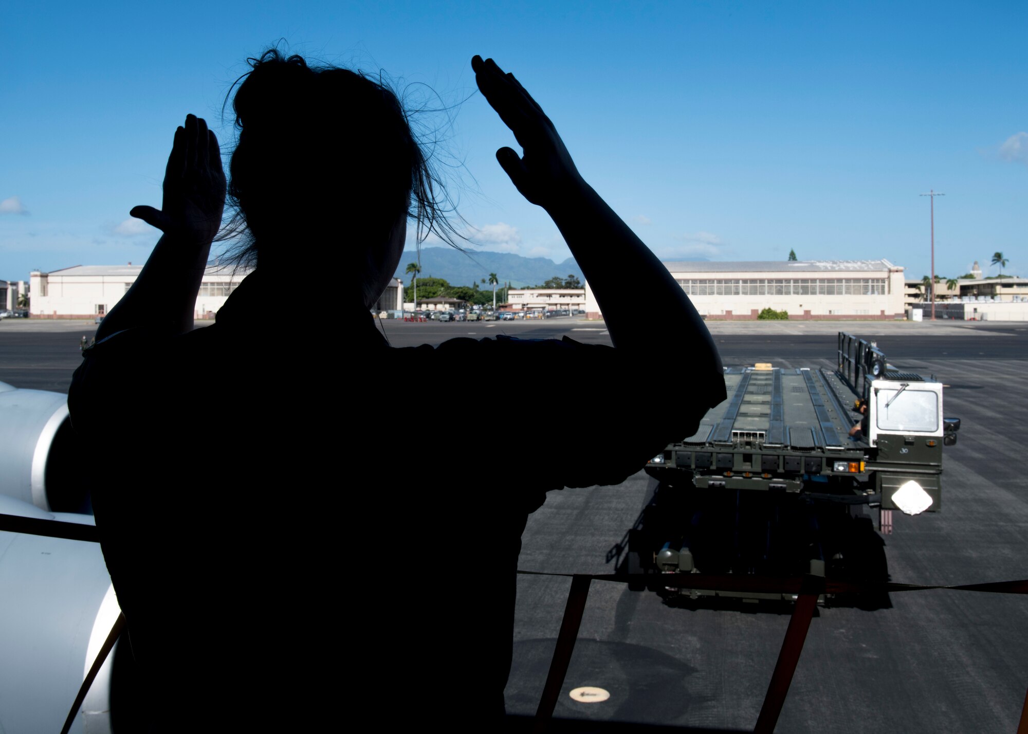 U.S. Air Force Airman 1st Class Allyson Molloy, 97th Air Refueling Squadron boom operator, guides a heavy cargo loader toward a KC-135 Stratotanker to load aeromedical evacuation supplies at Joint Base Pearl Harbor-Hickam, Hawaii, Nov. 10, 2020. Aeromedical evacuation is one the most important and challenging missions for aircrew, and can take place at anytime, anywhere.. (U.S. Air Force photo by Senior Airman Lawrence Sena)