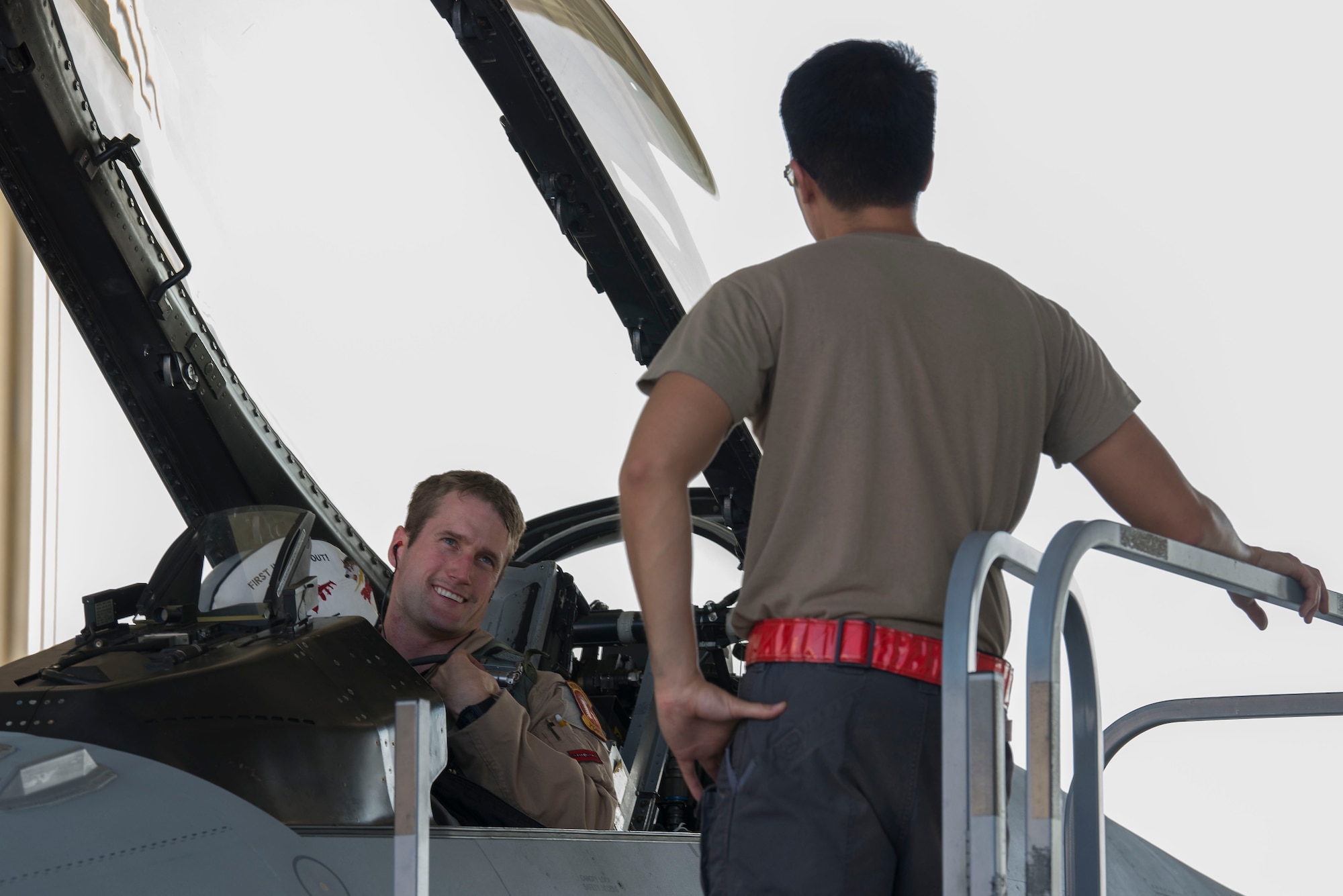 U.S. Air Force Capt. Logan Mitchell, 480th Fighter Squadron F-16 Fighting Falcon pilot, speaks with Senior Airman Peter Ho, 380th Expeditionary Aircraft Maintenance Squadron crew chief, upon arrival at Al Dhafra Air Base, United Arab Emirates, Nov. 12, 2020.