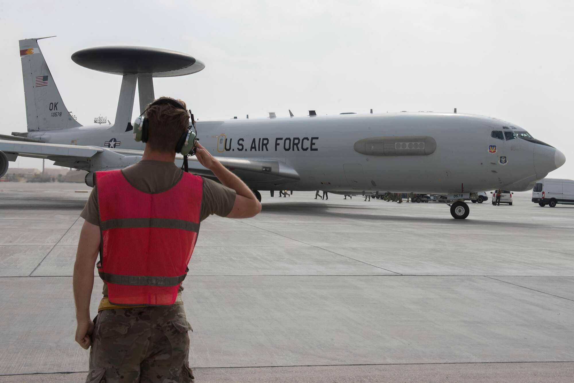 A U.S. Airman assigned to the 380th Expeditionary Maintenance Squadron Sentry aircraft maintenance unit salutes as an E-3G Sentry Airborne Warning and Control System aircraft taxis on the runway at Al Dhafra Air Base, United Arab Emirates, Nov. 8, 2020.
