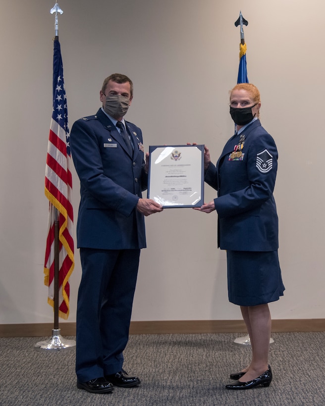 Col. Carl Spear, 403rd Aeromedical Staging Squadron commander, presents the certificate of retirement to Master Sgt. Tammy Campbell, 403rd ASTS chief of health service management, during her retirement ceremony Nov. 7, 2020 at Keesler Air Force Base, Miss. Campbell retired as an Air Force Reserve Technician after 36 years of service; 30 of which were served in various positions across the 403rd Wing. (U.S. Air Force photo by 2nd Lt. Christopher Carranza