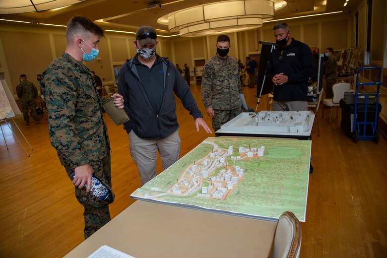 David W. VanHorn, center, the assistant site lead at the Infantry Immersion Trainer, Marine Corps Base Camp Lejeune, shows a Marine with 2nd Marine Division a new range under construction that simulates real life scenarios that can take place during combat missions during the Warfighter Training Symposium at Marston Pavilion on MCB Camp Lejeune, North Carolina, Nov. 4, 2020. The symposium provided more than 150 leaders with information on facilities available on MCB Camp Lejeune to Marines for training and provides an opportunity to inquire about range complex capabilities. (U.S. Marine Corps photo by Cpl. Ginnie Lee)
