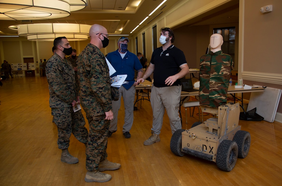 Mathew Cork, right, manager for Marathon Targets, informs Marines with 2nd Marine Division about the use of robotic targets during combat simulations for effective fire and movement during the Warfighter Training Symposium at Marston Pavilion on MCB Camp Lejeune, North Carolina, Nov. 4, 2020. The symposium provided more than 150 leaders with information on facilities available on MCB Camp Lejeune to Marines for training and provides an opportunity to inquire about range complex capabilities. (U.S. Marine Corps photo by Cpl. Ginnie Lee)