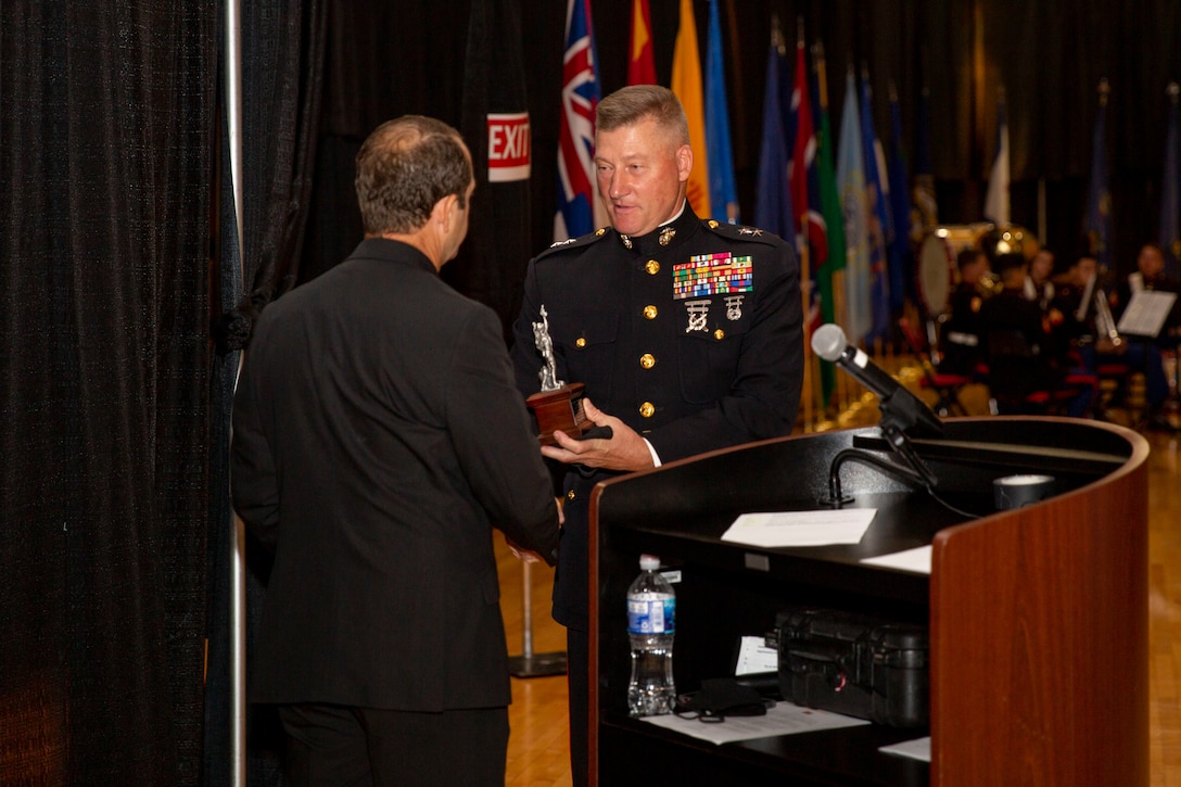 Michael Lazzara, left, Jacksonville Mayor pro tempore and the guest of honor, accepts a gift from U.S. Marine Corps Maj. Gen. Julian D. Alford, right, commanding general, Marine Corps Installations East-Marine Corps Base Camp Lejeune, at the MCIEAST-MCB Camp Lejeune cake cutting ceremony at the Goettge Memorial  Field House on MCB Camp Lejeune, North Carolina, Nov. 10, 2020. Marines with MCIEAST-MCB Camp Lejeune celebrated the 245th Marine Corps birthday by reading the birthday message from Gen. John A. Lejeune, 13th Commandant of the Marine Corps and cutting the traditional birthday cake while adhering to COVID-19 mitigation protocols. (U.S. Marine Corps photo by Lance Cpl. Christian Ayers)