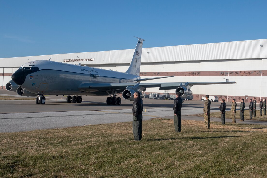 A formation of Airmen salute an aircraft