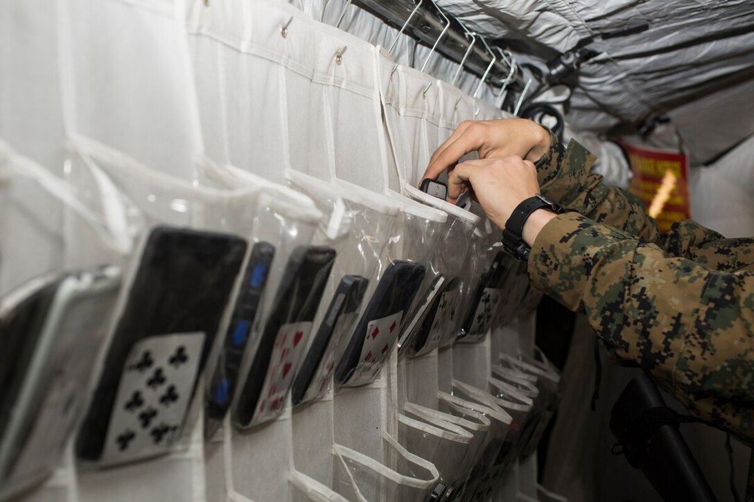 U.S. Marine Lance Cpl. Benjamin Dippe, 3rd Law Enforcement Battalion, military policeman, secures a personal cellphone during Combined Marine Component Command, Command Post Exercise at the III Marine Expeditionary Force Entry Control Point (ECP) on Camp Mujuk, Republic of Korea (ROK), March 19, 2015. U.S. Marines and ROK Marines stand duty at the ECP to ensure security measures are taken by performing mandatory baggage checks, roving patrols, securing and logging electronics, and inspecting that all personnel have participant badges. (U.S. Marine Corps photo by MCIPAC Combat Camera Pfc. Makenzie Fallon)