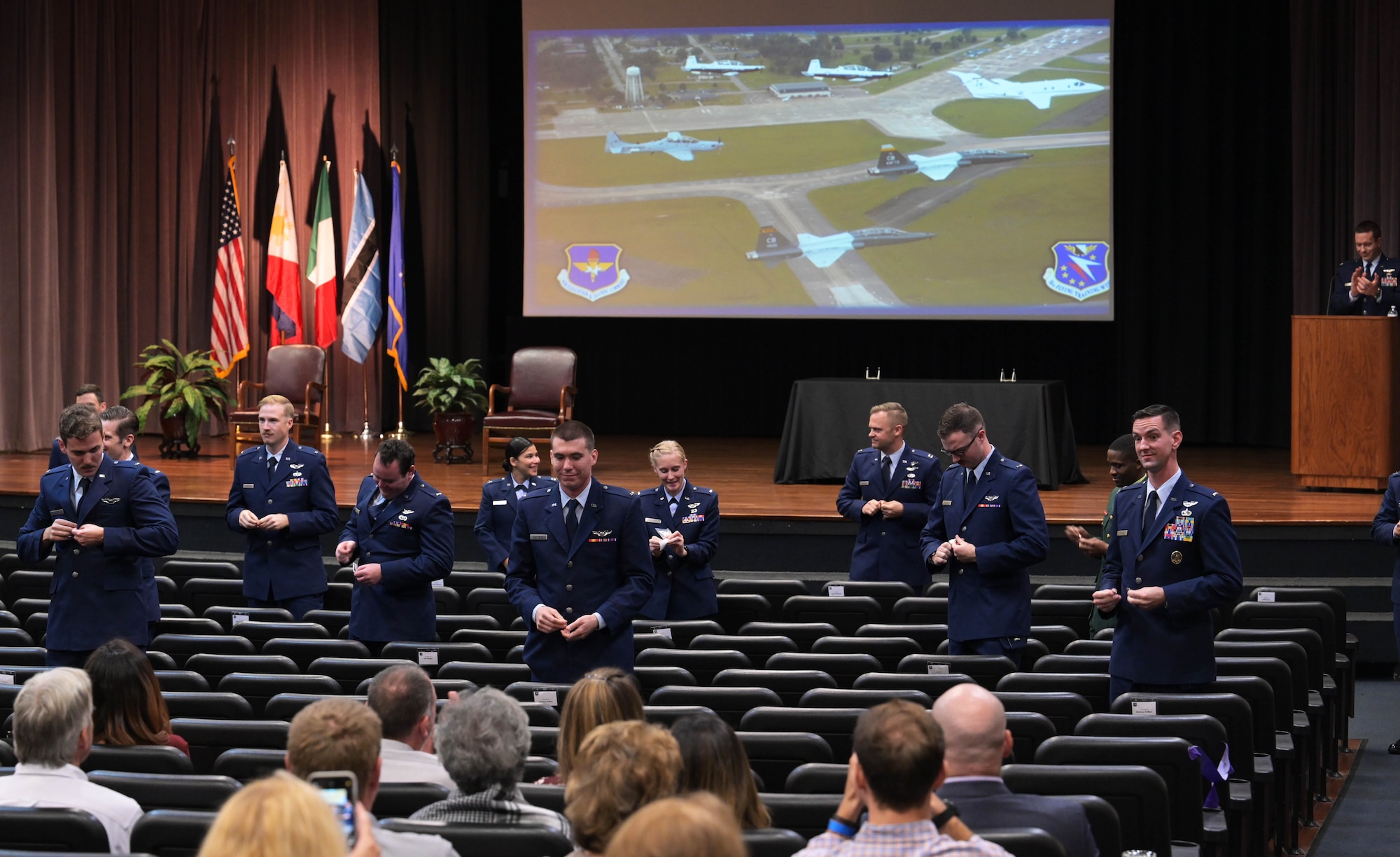 The graduating class of 21-02 stands to break their silver wings in half Nov. 13, 2020, on Columbus Air Force Base Miss. To graduate, students completed 52 weeks of pilot training with six-weeks of preflight academics and physiological training followed by primary training. (U.S. Air Force photo by Senior Airman Jake Jacobsen)