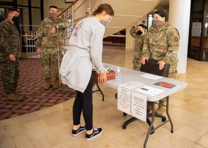 An Airman takes a meal from a table.