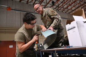Master Sgt. Harold Fulghum and Senior Airman Acacia Shelton, aircraft structural technicians with the 507th Maintenance Squadron smooth the edge of new engine intake section they fabricated in-house over a three-week period. The structures shop spent 192 hours fabricating a part in-house following a bird strike, saving the Air Force more than $1 million. (U.S. Air Force photo by Master Sgt. Grady Epperly)