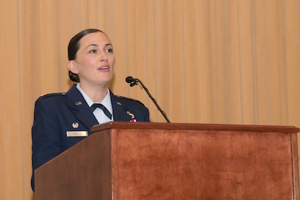 An Airman speaks while standing at a podium